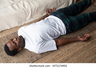 Young Black Man Lying In Dead Body Exercise Or Corpse Pose With His Eyes Closed, Savasana Pose