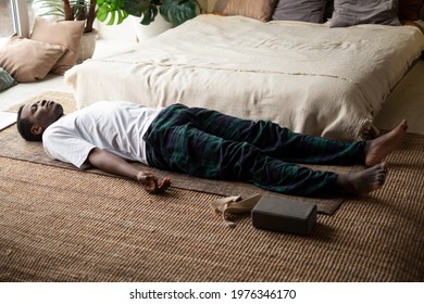 Young Black Man Lying In Dead Body Exercise Or Corpse Pose With His Eyes Closed, Savasana Pose