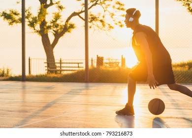 young black man playing basketball on court, morning exercises, active lifestyle, warm sunlight, doing sports on sunrise