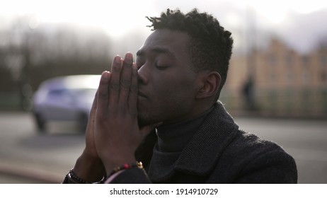 Young black man praying to GOD. Religious African person seeking divine help