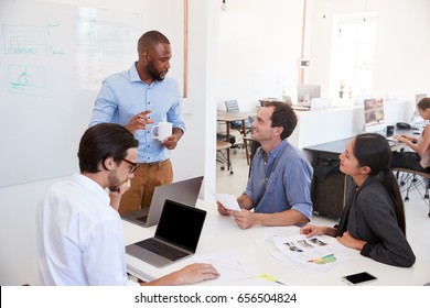 Young Black Man Presenting An Office Meeting At A Whiteboard