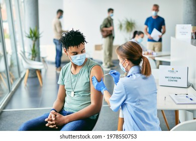 Young Black Man Receiving COVID-19 Vaccine During Immunization At Vaccination Center.