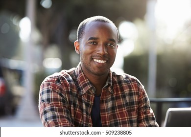 Young Black Man Sitting Outdoors, Portrait