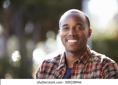 Young Black Man Sitting Outside, Head And Shoulders Portrait