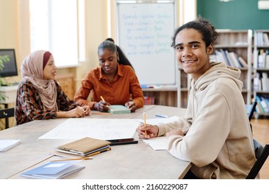 Young Black man sitting at table enjoying learning English language at school for immigrants smiling at camera - Shutterstock ID 2160229087