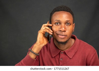 Young Black Man With A Slight Smirk Face While Making A Phone Call