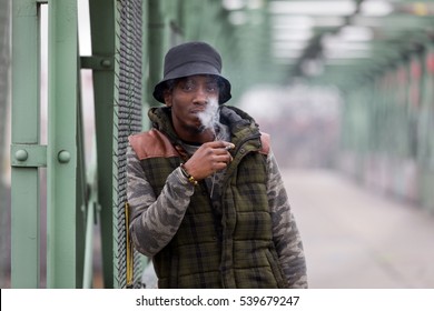 Young Black Man Smoking Cigarette On Street