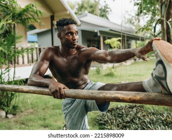 Young Black Man Stretching Leg Outdoors High Quality Photo