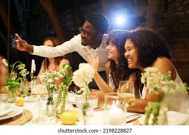 Young Black Man Taking Selfie With Happy Intercultural Lesbian Brides Boasting With Their Wedding Rings By Served Festive Table