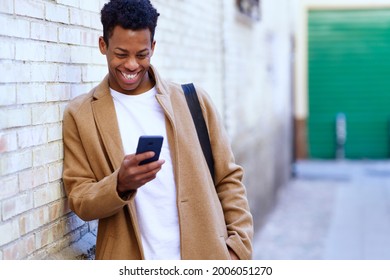 Young black man using his smartphone outdoors.