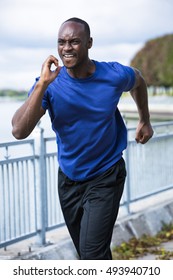 Young Black Man Wearing Athletic Wear Running Around The Lake