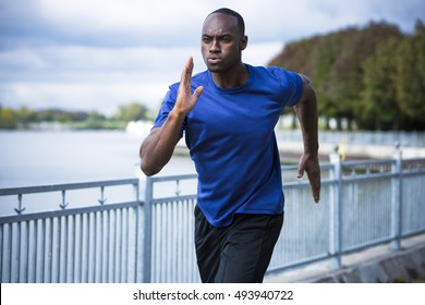 Young Black Man Wearing Athletic Wear Running Around The Lake