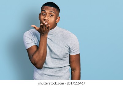 Young Black Man Wearing Casual T Shirt Looking At The Camera Blowing A Kiss With Hand On Air Being Lovely And Sexy. Love Expression. 