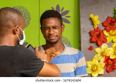 Young Black Man Wearing A Face Mask Checks On Someone Coughing Close To Him