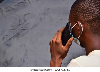 Young Black Man Wearing A Face Mask Making A Phone Call Close Up