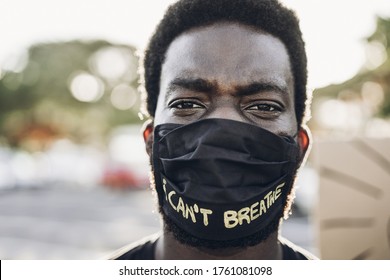 Young black man wearing face mask during equal rights protest - Concept of demonstrators on road for Black Lives Matter and I Can't Breathe campaign - Focus on eyes - Powered by Shutterstock