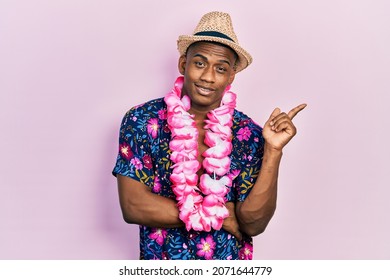 Young Black Man Wearing Summer Shirt And Hawaiian Lei Smiling Happy Pointing With Hand And Finger To The Side 