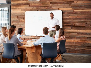 Young Black Man At Whiteboard Giving A Business Presentation