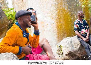 Young black men sitting on a rock relaxing - Powered by Shutterstock