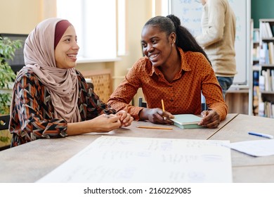 Young Black and Middle Eastern women having fun chatting about something during English lesson for immigrants - Shutterstock ID 2160229085