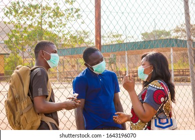 young black people wearing face masks having a conversation - Powered by Shutterstock