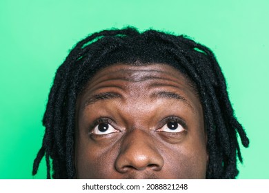 Young black perplexed man posing and looking upward isolated over green background - Shutterstock ID 2088821248