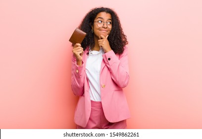 Young Black Pretty Business Woman With A Wallet Against Pink Wall Background