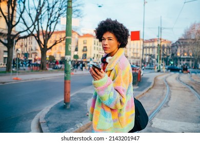 Young Black Smiling Woman Traveler Using Smartphone Outdoor Sightseeing Carrying Duffle Bag