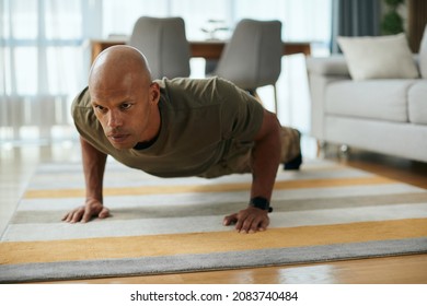 Young Black Soldier Doing Push-ups While Working Out In The Living Room.