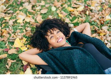 Young black successful woman with afro hair style relaxing in autumn. Happiness and relax concept.