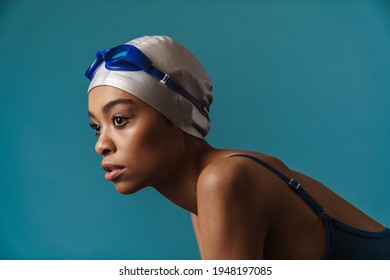 Young Black Swimmer In Goggles Posing And Looking Aside Isolated Over Blue Wall