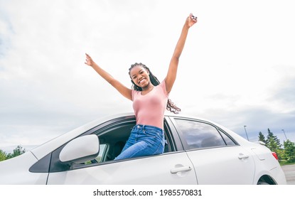A Young black teenage driver seated in her new car