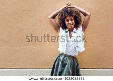 Similar – Young black woman, afro hairstyle, smiling near a wall in the street