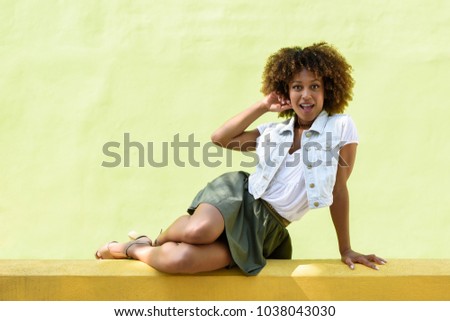 Similar – Young black woman, afro hairstyle, smiling near a wall in the street