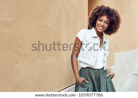 Similar – Young black woman, afro hairstyle, smiling near a wall in the street