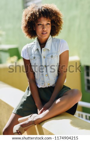 Similar – Young black woman, afro hairstyle, smiling near a wall in the street