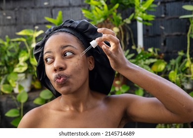 Young Black Woman Woman Applying Hyaluronic Serum From Dropper. Skincare Concept.