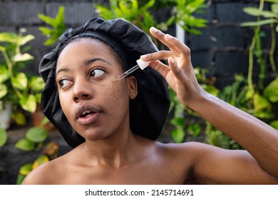 Young Black Woman Woman Applying Hyaluronic Serum From Dropper. Skincare Concept.