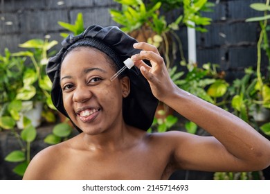 Young Black Woman Woman Applying Hyaluronic Serum From Dropper. Skincare Concept.