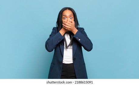 Young Black Woman Covering Mouth With Hands With A Shocked, Surprised Expression, Keeping A Secret Or Saying Oops. Business Concept