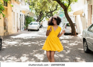 Young Black Woman With Curly Hair, In Yellow Dress And With Styles, Attitude, Laughing, Happy