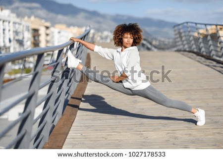 Similar – Young black woman doing stretching after running outdoors