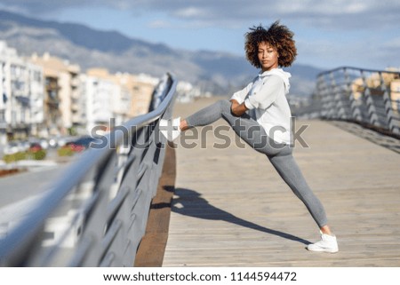 Similar – Young black woman doing stretching after running outdoors