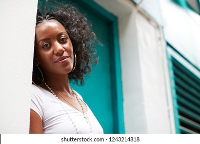 Young Black Woman In Doorway Smiling To Camera, Close Up