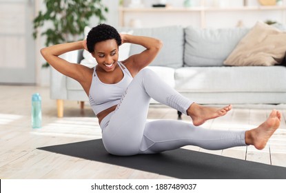 Young Black Woman Exercising In Her House Gym, Doing Abs Exercises, Working Out At Home During Coronavirus Quarantine. Fit African American Lady In Sportswear Strengthening Her Core Muscles