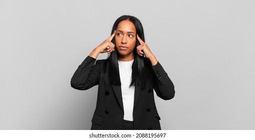 Young Black Woman Feeling Confused Or Doubting, Concentrating On An Idea, Thinking Hard, Looking To Copy Space On Side. Business Concept