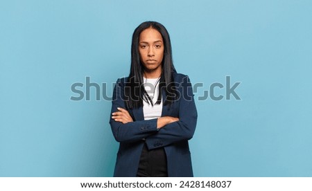 young black woman feeling displeased and disappointed, looking serious, annoyed and angry with crossed arms. business concept