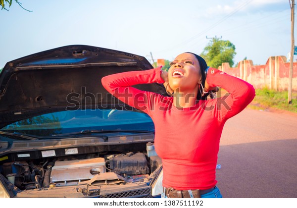 young black woman feeling frustrated after her car
breaks down