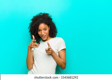 Young Black Woman Feeling Happy, Cool, Satisfied, Relaxed And Successful, Pointing At Camera, Choosing You Against Blue Wall