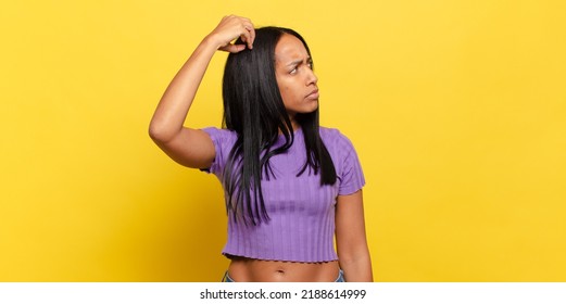 Young Black Woman Feeling Puzzled And Confused, Scratching Head And Looking To The Side